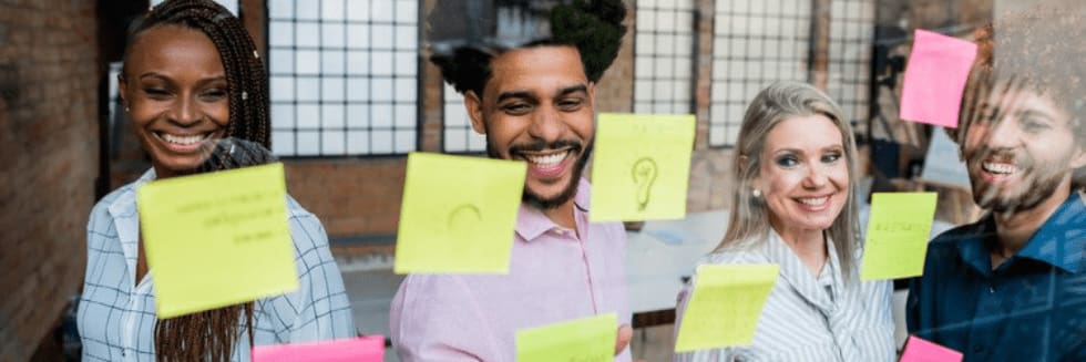 A team of four professionals engages in a design thinking exercise.