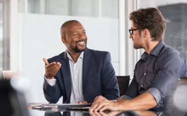 Team members use business communication skills during a meeting.