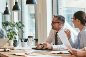 Group of business professionals talking and collaborating in a workplace.