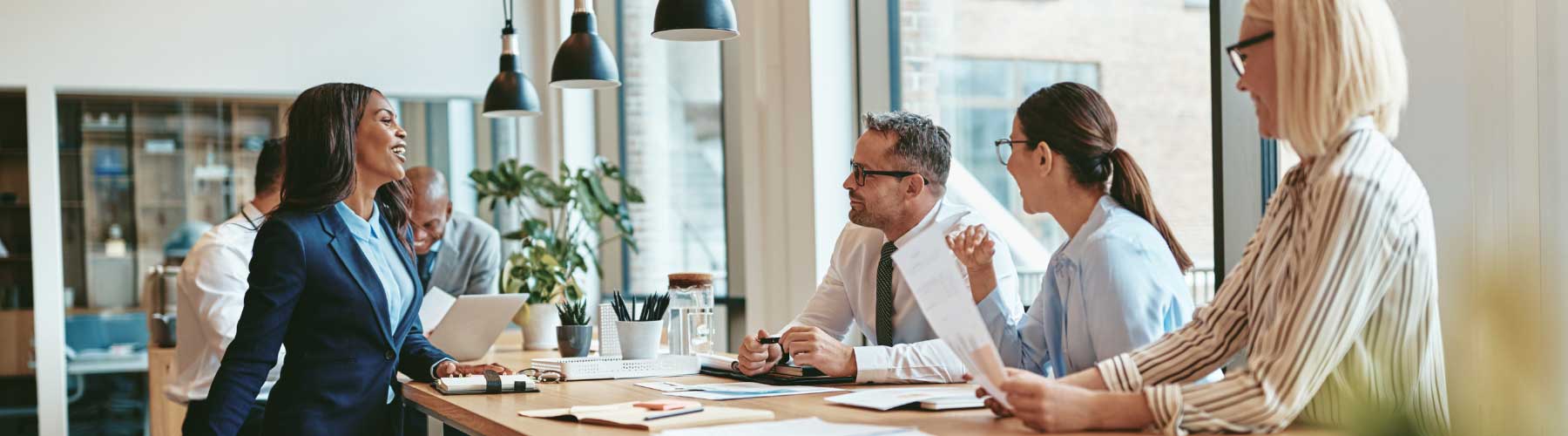 Group of business professionals talking and collaborating in a workplace.