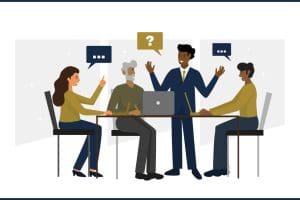 A group of business professionals sitting at a table talking with one standing.