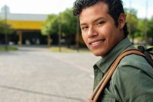 A veteran student wearing a backpack on a college campus.