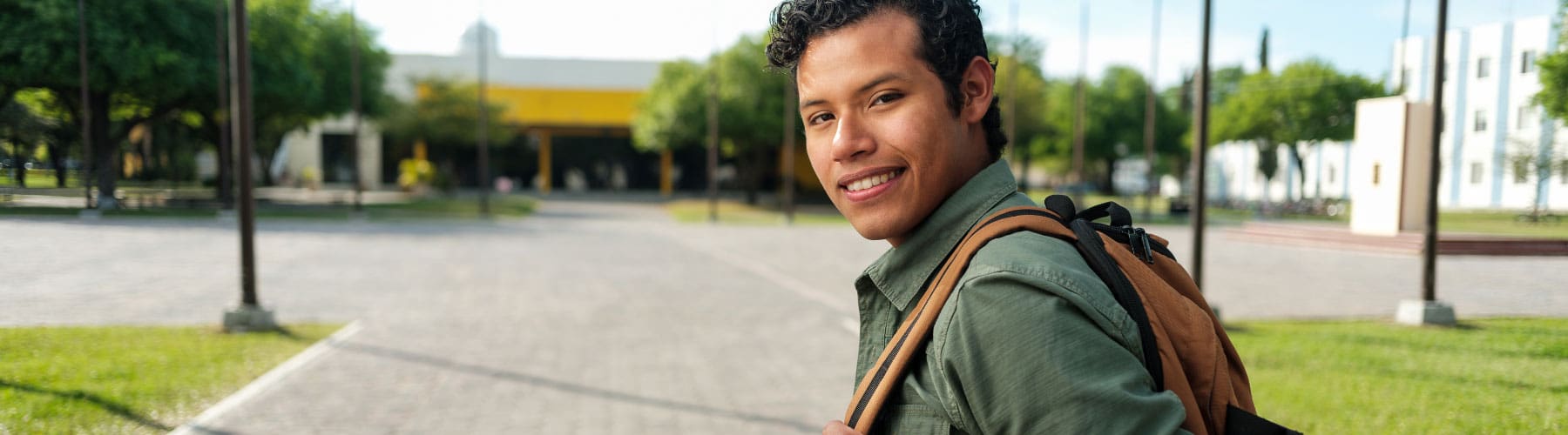 A veteran student wearing a backpack on a college campus.