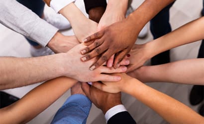 Stack of individuals hands uniting.